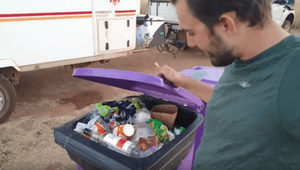 Ed Looking into a Garbage bin full of single use plastic